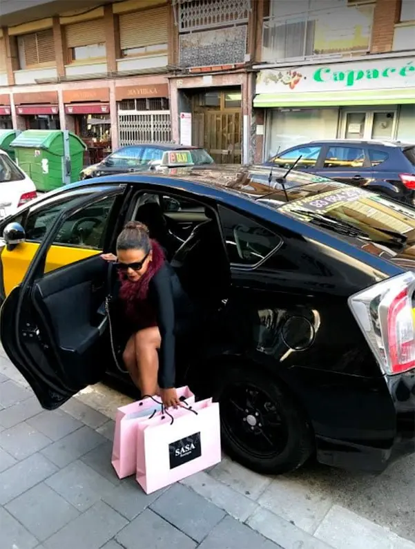 Clienta bajando de un taxi de Castelldefels con bolsas de la compra